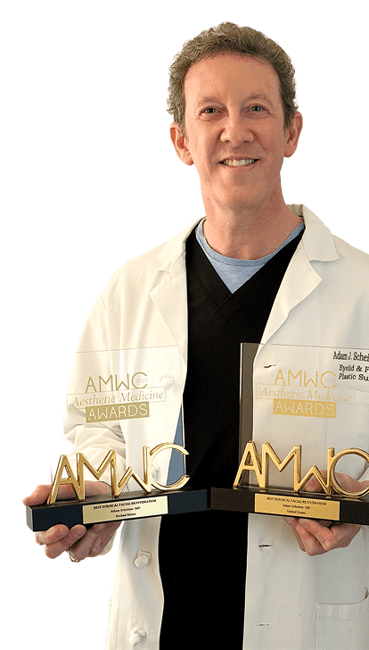 Dr. Adam Scheiner holding two AMWC awards.