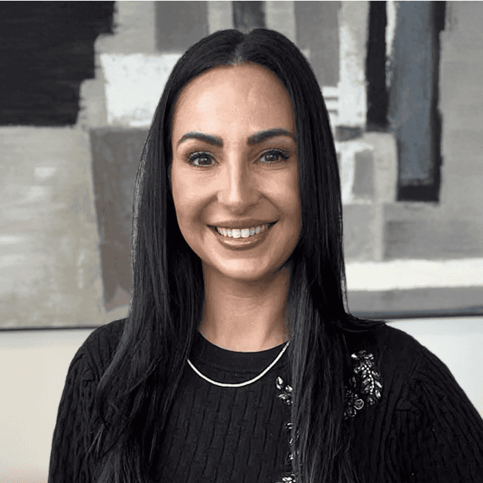 Alejandra poses in matching black top and skirt with her hand on her hip.