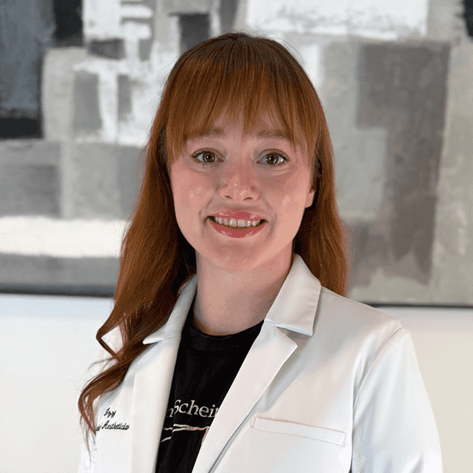 Izzy smile shines as her auburn hair falls over her black scrubs.