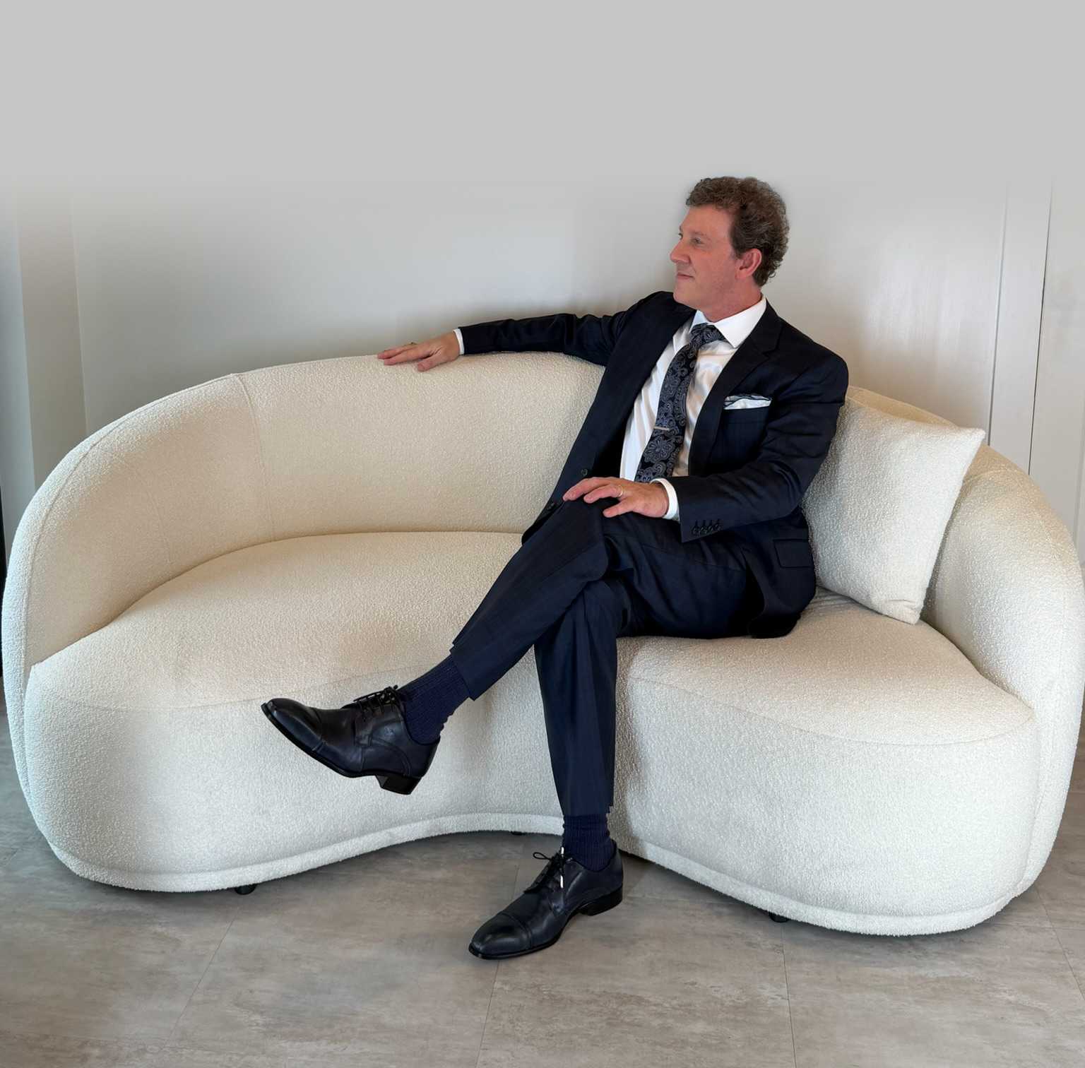 Adam Scheiner, M.D. relaxing on a sofa.